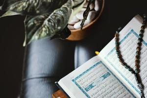 der heilige koran und rosenkranz oder tasbih auf minimalistischem schwarzem interieur foto