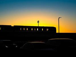 Silhouette des ein- oder ausgehenden Sky Train im wunderschönen Sonnenuntergang. foto