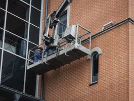 Arbeiter reparieren Fassade des Gebäudes foto