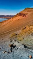 isländische landschaft der farbenfrohen vulkanischen caldera askja, mitten in der vulkanischen wüste im hochland, mit roter, türkisfarbener vulkanerde und blauem himmel, island foto