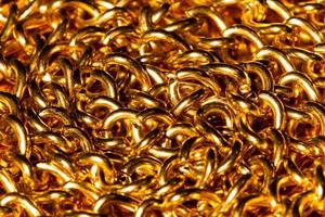 goldene Kette. Detail einer gelben Eisenkette. Metallkettenglied auf dem goldenen Hintergrund. dekorativer Schmuck. Luxusdesign brillanter Schmuck. Schönheit goldene Halskette. Makrofoto für Anzeigen, Flyer. Nahansicht foto