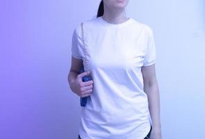 eine junge frau ist in ein leeres weißes t-shirt-modell für aufschriften, werbung, zeichnung in neonlicht gekleidet foto