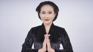 asiatische frau in kebaya lächelnd gestikulieren willkommen isoliert auf weißem hintergrund foto