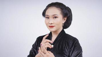 asiatische Frau in schwarzem Kebaya sieht feminin aus, isoliert auf weißem Hintergrund foto