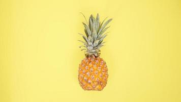 eine Ananas isoliert auf gelbem Hintergrund foto
