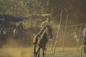 junger mann jockeys in pferderennfahrern bei hus traditionelle pferderennkultur von rote island, ost nusa tenggara, indonesien. rote, indonesien - 27. märz 2020 foto