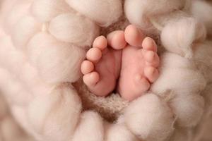 weiche neugeborene babyfüße gegen eine braune decke foto