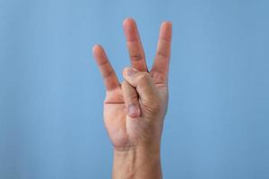 Office-Syndrom-Konzept. Ringfinger ist nach der Arbeit gestreckt. Nahaufnahme isoliert auf blauem Hintergrund. Vorhandansicht. foto