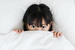 Porträt eines Mädchens, das im Bett liegt foto