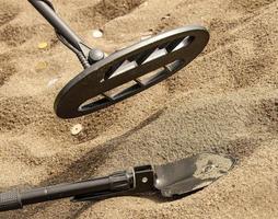 der Metalldetektor, Ring und Spaten auf dem Sand foto