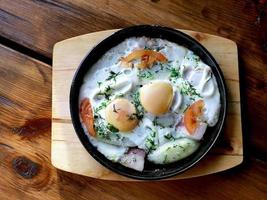 Rührei mit Speck und Zwiebeln in der Pfanne. hausgemachtes Essen foto