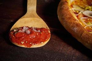 Löffel mit Tomatenmark und Pizza foto