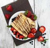 Crêpes mit Erdbeeren und Schokoladensauce foto