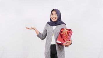 asiatisches Mädchen, das ein Geschenk trägt, das Seitenleerzeichen lokalisiert auf weißem Hintergrund zeigt foto