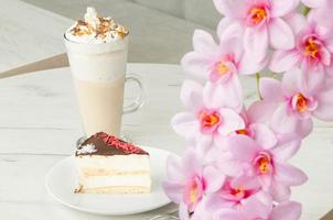 Kuchen in einem Teller und ein Glas Cocktail auf einem Tisch foto