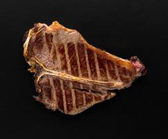 ein Stück frisch gegrilltes Fleisch auf schwarzem Hintergrund foto