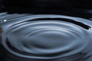Kreise auf dunklem Wasser. glänzende Oberfläche. Banner mit flüssigem Hintergrund. foto