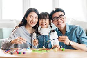 Bild der Familie, die zusammen sitzt und malt foto