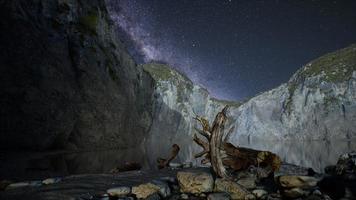 hyperlapse des nächtlichen sternenhimmels mit berg- und ozeanstrand auf den lofoten norwegen foto