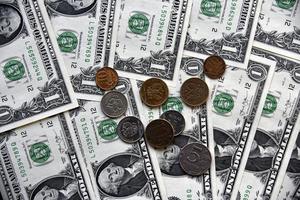 Rubel und Münzen auf dem Hintergrund von Dollarnoten foto
