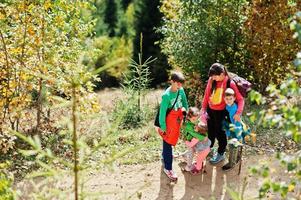 Mutter mit vier Kindern in den Bergen. Familienreisen und Wandern mit Kindern. Schwestern umarmen sich. foto