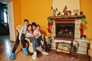 glückliche vier kinder zu hause am kamin im warmen wohnzimmer am wintertag. foto
