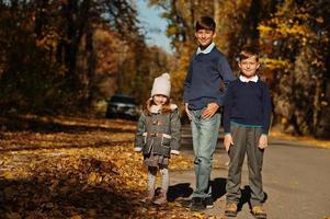 Drei Kinder posieren im Herbstpark. foto