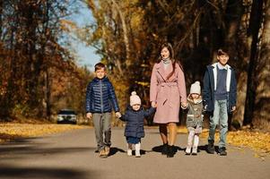 Mutter mit vier Kindern im Herbstpark. Familienwanderung im Herbstwald.