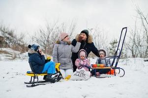 Familienspiele und Schlittenfahrten im Winter im Freien, Kinder haben Spaß, Tee trinken. foto