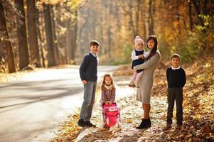 Mutter mit vier Kindern im Herbstpark. Familienwanderung im Herbstwald. foto