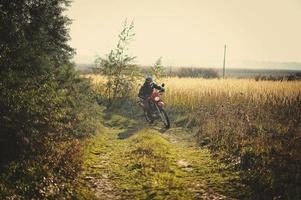 Enduro-Rennfahrer sitzt auf seinem Motorrad foto