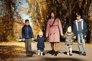 Mutter mit vier Kindern im Herbstpark. Familienwanderung im Herbstwald. foto