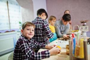 mutter mit vier kindern macht einen kranz für heiligabend und bastelt dekorieren. Neujahr Feierlichkeiten. foto