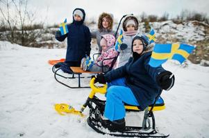 skandinavische familie mit schwedenflagge in der schwedischen winterlandschaft. foto