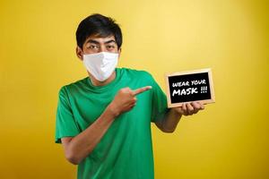 porträt eines jungen asiatischen mannes, der eine schutzmaske gegen das coronavirus trägt foto