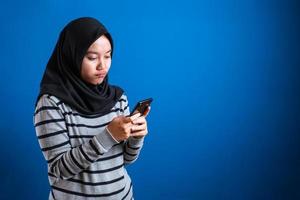 Porträt eines süßen, schönen asiatischen muslimischen Teenager-Mädchens, das Hijab trägt und traurig weint, wenn es schlechte Nachrichten am Telefon erhält foto