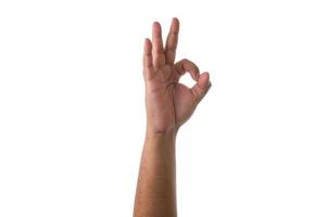 Hand zeigt OK-Zeichen vor weißem Hintergrund foto