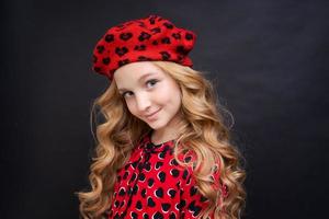 schönes junges kaukasisches mädchen, das französischen look mit roter mütze und kleid trägt foto