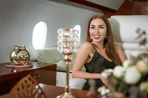 schöne reiche Frau in einem privaten First-Class-Flugzeug foto