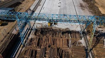 holzverarbeitende Industrie. Kran lädt Baumstämme Luftaufnahmen mit Drohne foto