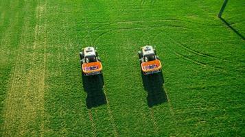 Traktor macht Dünger auf dem Feld. Luftaufnahme foto