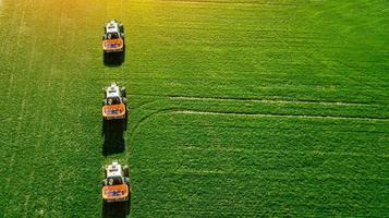 Traktor macht Dünger auf dem Feld. Ansicht von oben foto