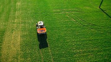 Traktor macht Dünger auf dem Feld. Luftaufnahme foto