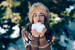 junge frau, die die schneebedeckten berge im winter genießt foto