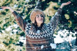 junge frau, die die schneebedeckten berge im winter genießt foto