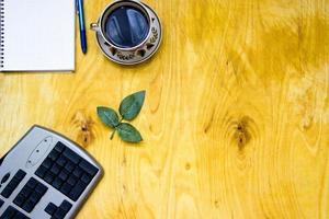 Tasse Kaffee und offenes Notizbuch auf Holzhintergrund foto