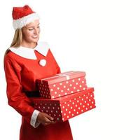 blonde frau in weihnachtsmannkleidung, die mit geschenkboxen lächelt. foto