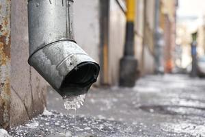 Abflussrohr mit gefrorenem Wasser im Winter auf der Moskauer Straße foto