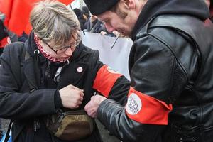 Moskau, Russland - 10. März 2019. Politische Kundgebung für ein kostenloses Internet. Nationalbolschewik bindet eine rote Armbinde mit dem Emblem der Partei am Arm des Mädchens foto