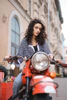 junge Frau sitzt auf einem Motorrad im Freien. foto